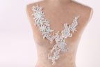 A mannequin torso with a delicate, intricate white lace design on the bust area.