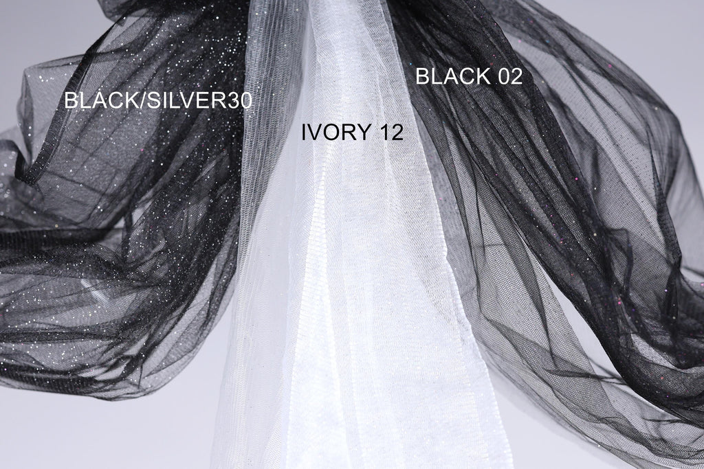a close-up view of a black and white fabric, with the black fabric appearing to be a sheer material and the white fabric possibly a sheer veil or chiffon. The black fabric is labeled as "BLACK/SILVER30" and the white fabric is labeled as "IVORY 12".