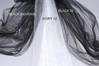 a close-up view of a black and white fabric, with the black fabric appearing to be a sheer material and the white fabric possibly a sheer veil or chiffon. The black fabric is labeled as "BLACK/SILVER30" and the white fabric is labeled as "IVORY 12".