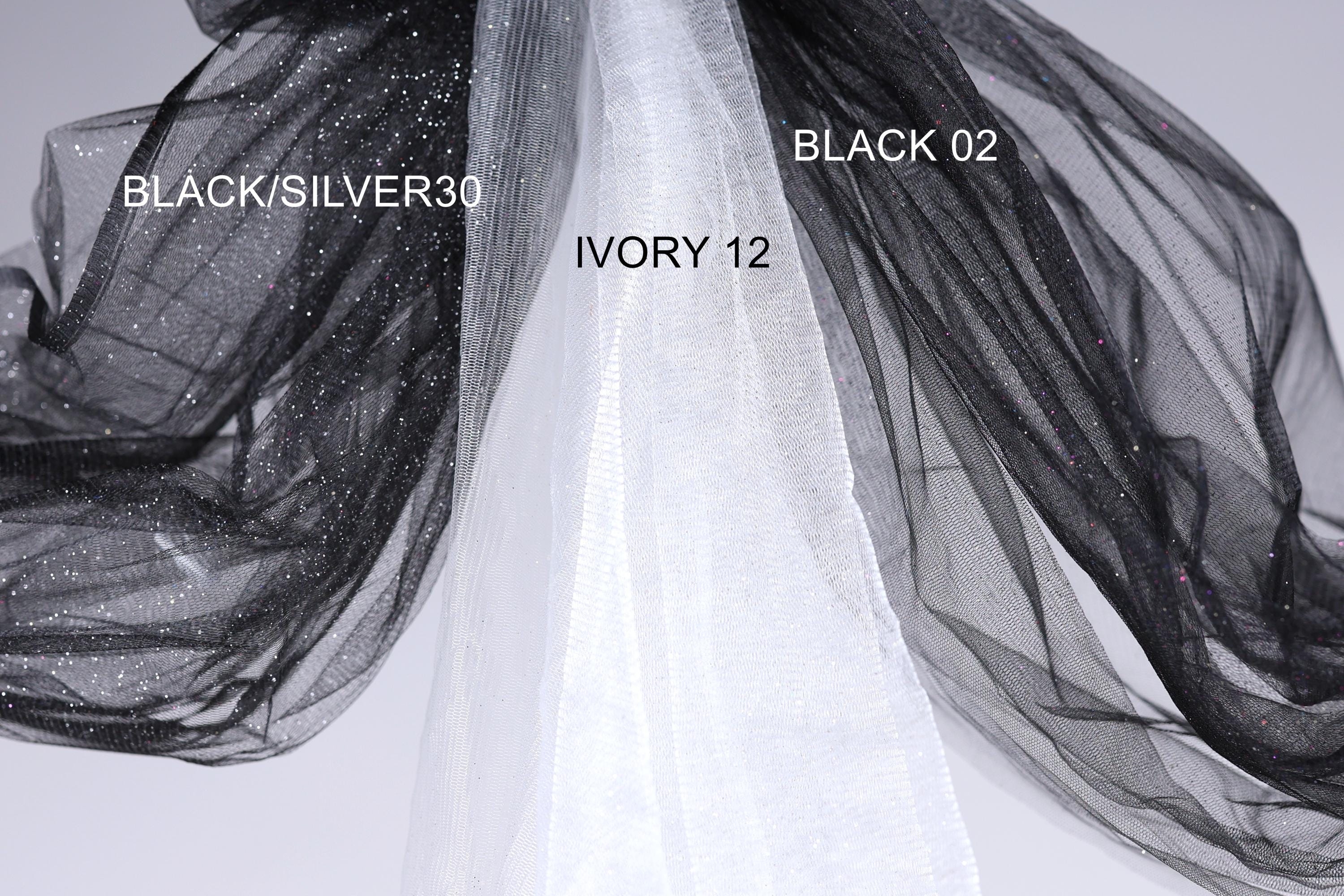 a close-up view of a black and white fabric, with the black fabric appearing to be a sheer material and the white fabric possibly a sheer veil or chiffon. The black fabric is labeled as "BLACK/SILVER30" and the white fabric is labeled as "IVORY 12".
