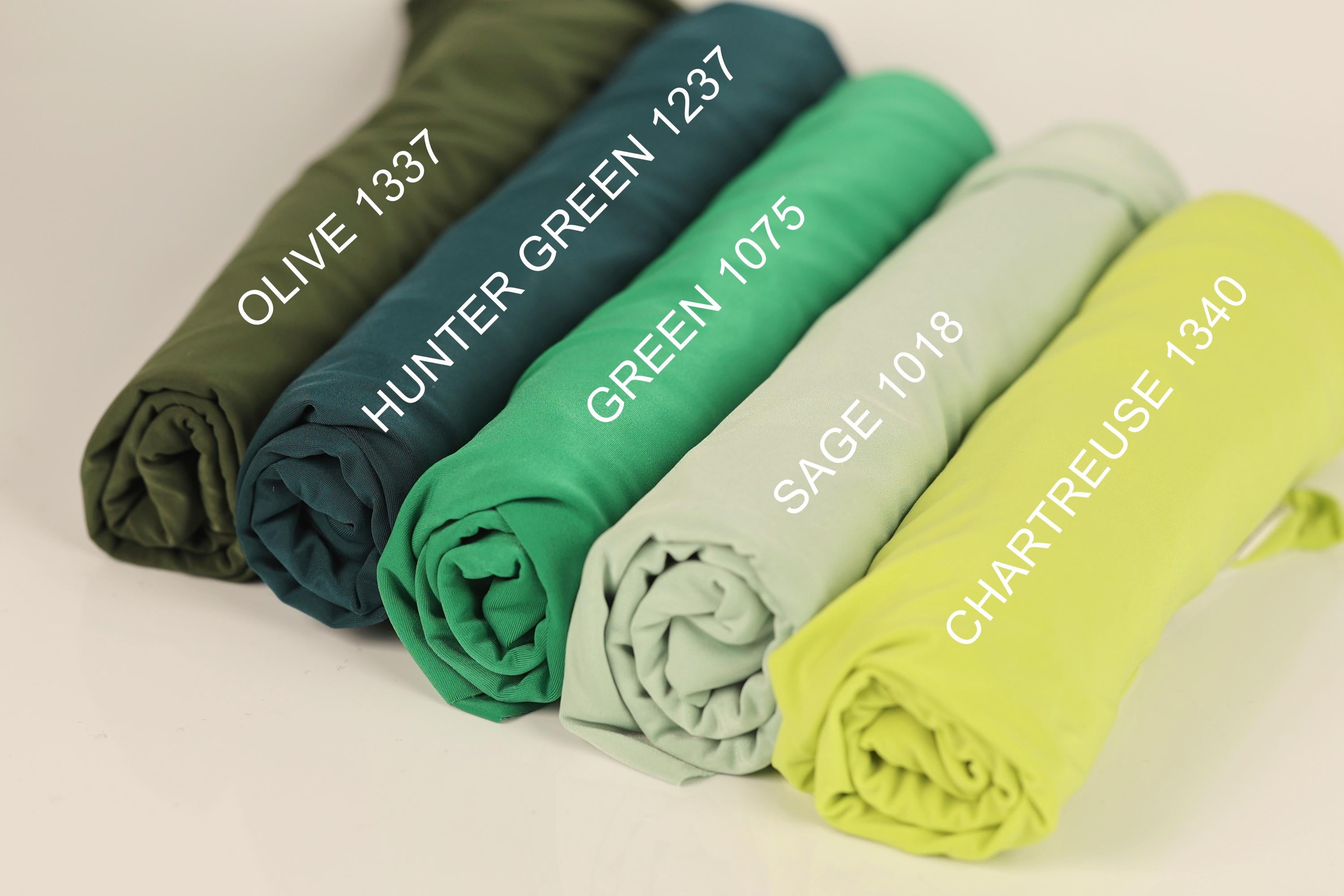 a collection of rolled-up fabric swatches in various colors, including olive green, green, green, green, and yellow.