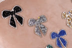 a close-up view of several decorative bows made of glittery materials, such as rhinestones or sequins, attached to a surface.