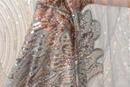 A close-up view of a sequined fabric, showcasing its intricate and colorful patterns.