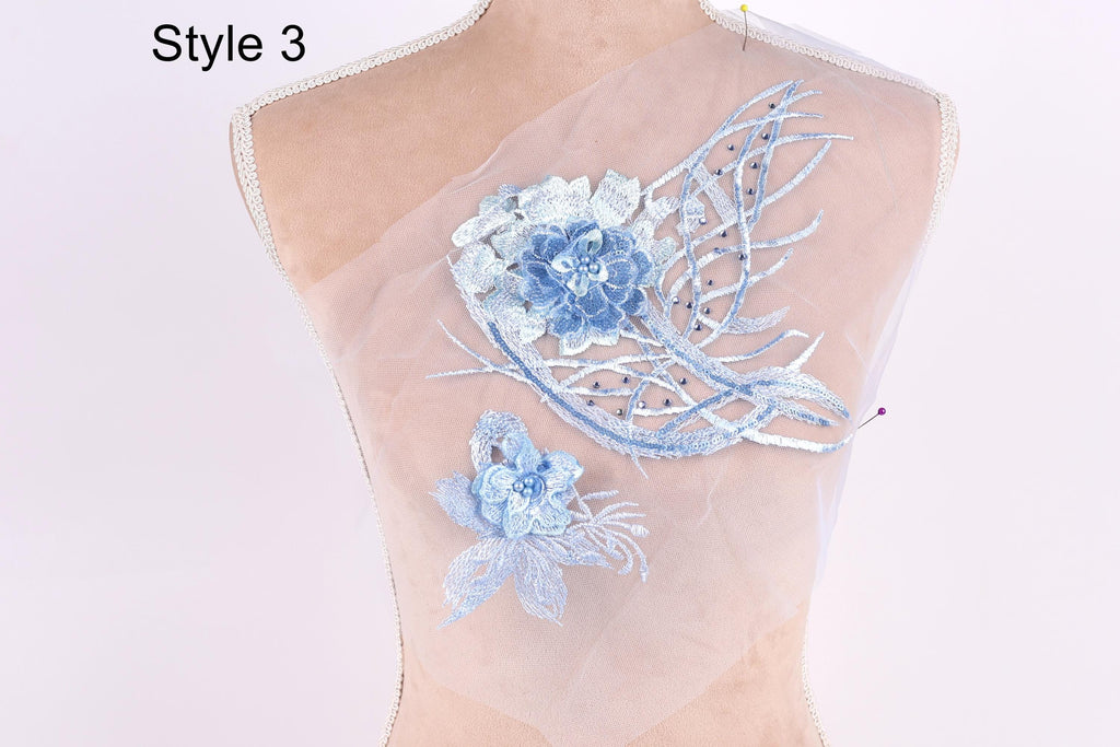 A mannequin with a sheer fabric back, adorned with a blue floral embroidery design.