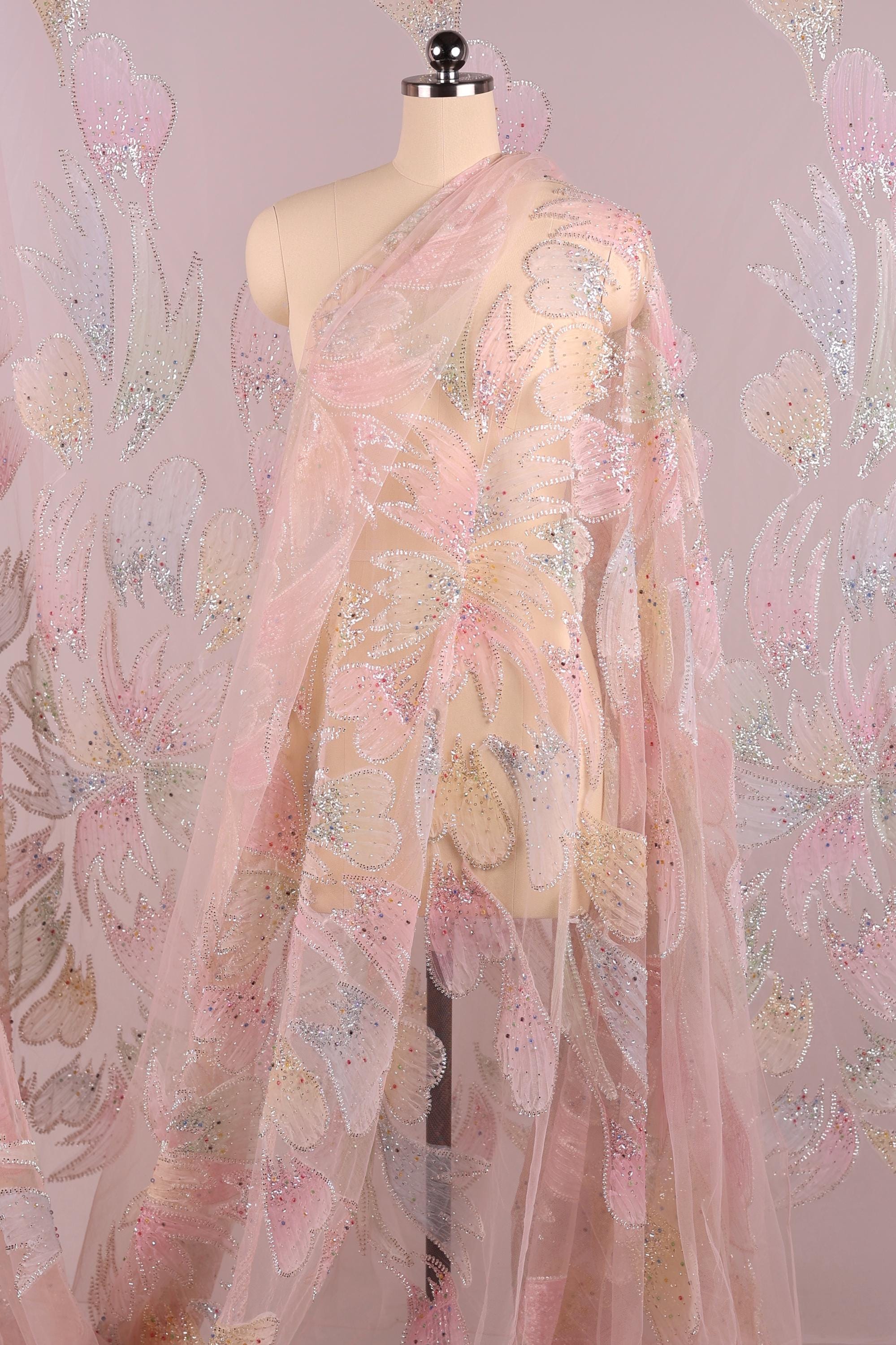 A mannequin wearing a pink and white floral print dress with a sheer, flowing skirt.