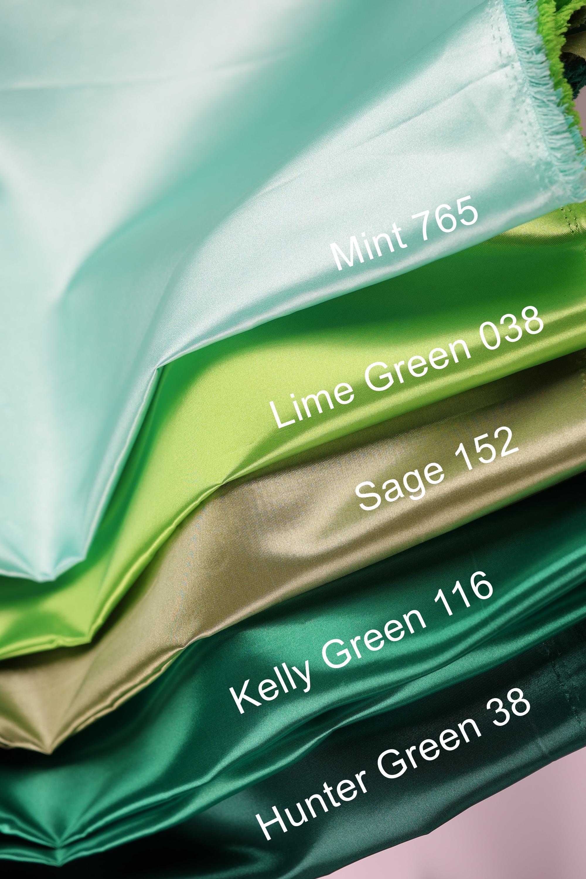 A close-up image of a stack of fabric swatches in various colors, including mint, lime green, sage, Kelly green, and hunter green.