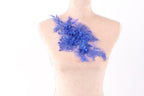 a mannequin torso with a decorative blue floral piece attached to it.