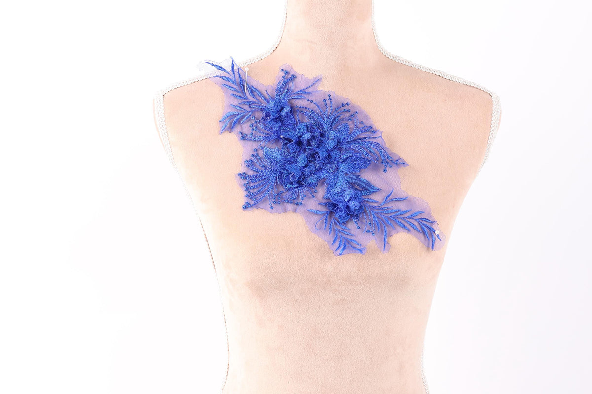a mannequin torso with a decorative blue floral piece attached to it.