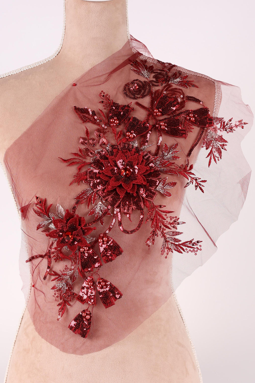 a red floral design with sequins and a sheer background.
