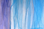 a close-up view of a piece of blue and purple fabric, with the fabric appearing to be made of sheer material. The fabric has a textured and layered appearance, with vertical lines and stripes creating a sense of depth and movement. The colors of the fabric are predominantly blue and purple, with hints of white and gray adding contrast and balance to the overall composition.