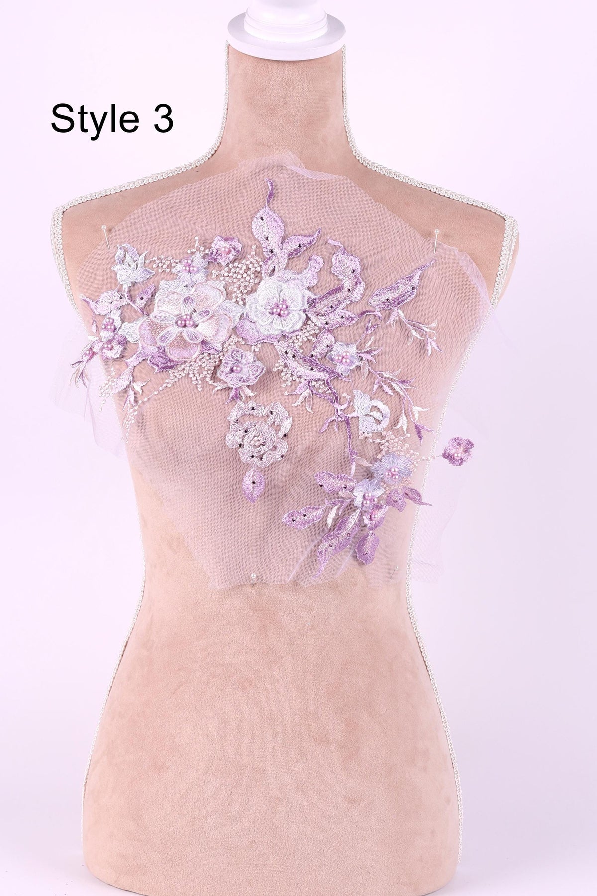 A mannequin with a decorative fabric on its bust, featuring a floral pattern in shades of purple and white.