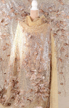 a mannequin wearing a gold and beige sequined dress with a floral pattern.