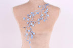 a mannequin torso with a delicate blue floral embroidery on the back.