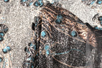 a close-up view of a black and gold sequined fabric with intricate floral and leaf designs.