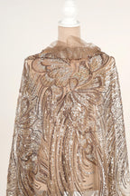 a mannequin wearing a gold and beige sequined dress with a floral pattern.