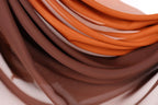 a close-up view of a pile of brown and orange fabric, with the colors blending together to create a visually appealing pattern.