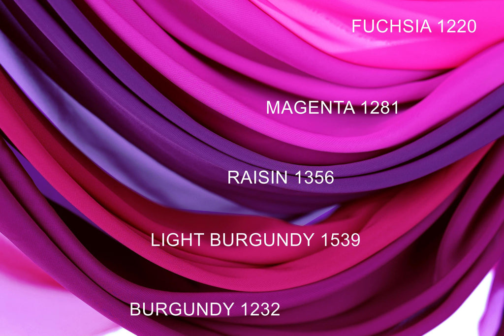 a close-up view of a variety of colorful fabrics, including magenta, burgundy, and light burgundy, arranged in a visually appealing manner.