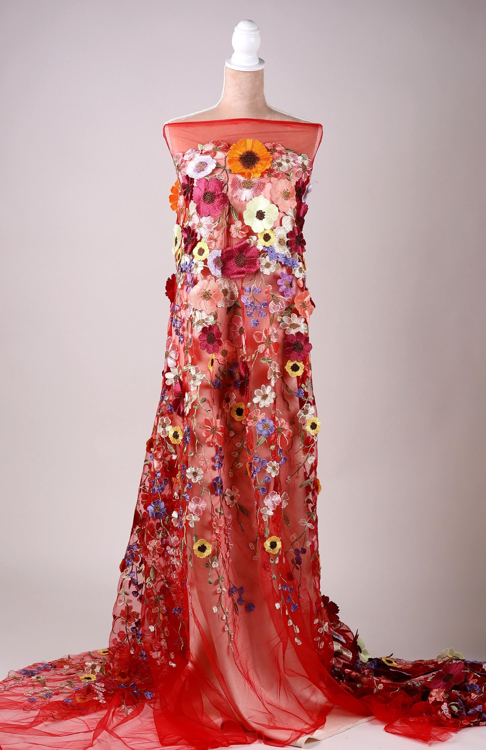 A mannequin wearing a long, red dress with a floral pattern.
