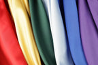 A close-up view of a variety of colorful fabric swatches, including red, yellow, green, white, blue, and purple.