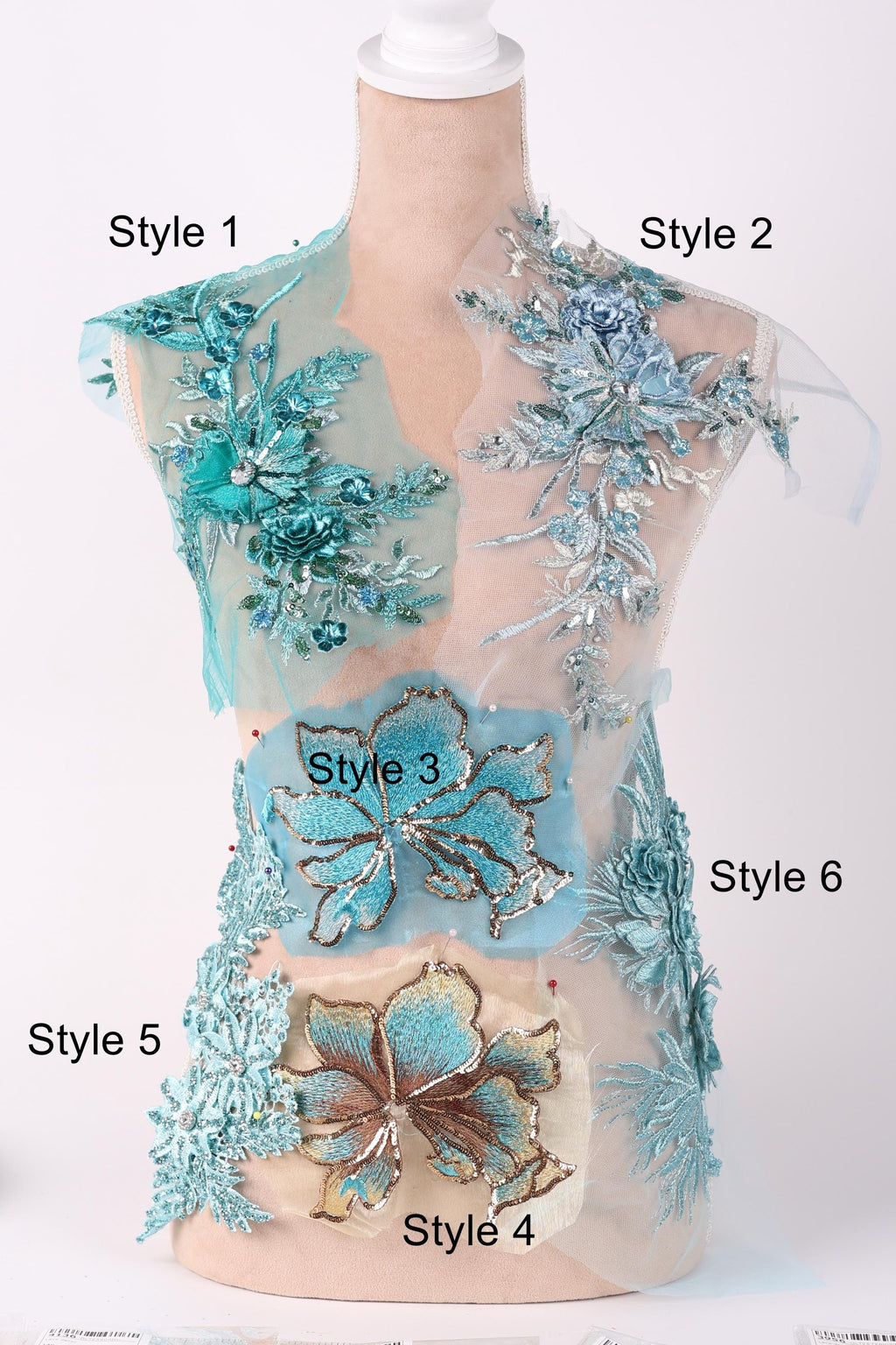 A mannequin with various styles of blue and green floral embroidery displayed on its bust and hips.