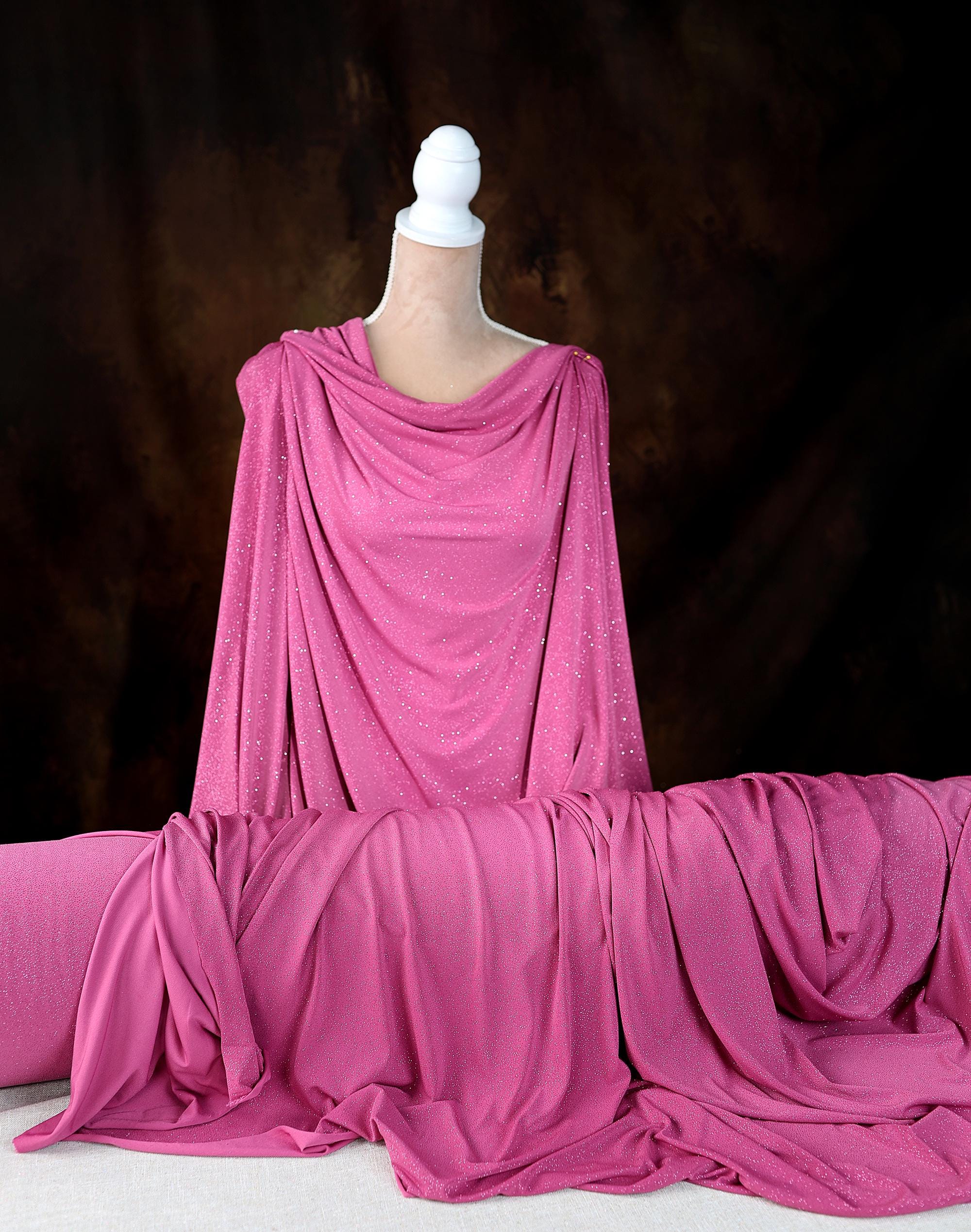 a mannequin wearing a pink draped dress