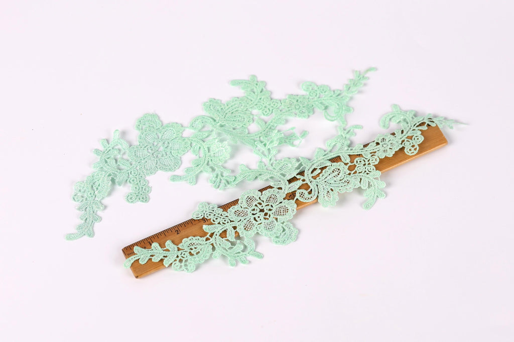 a close-up view of a wooden ruler with delicate, green lace-like patterns on it.
