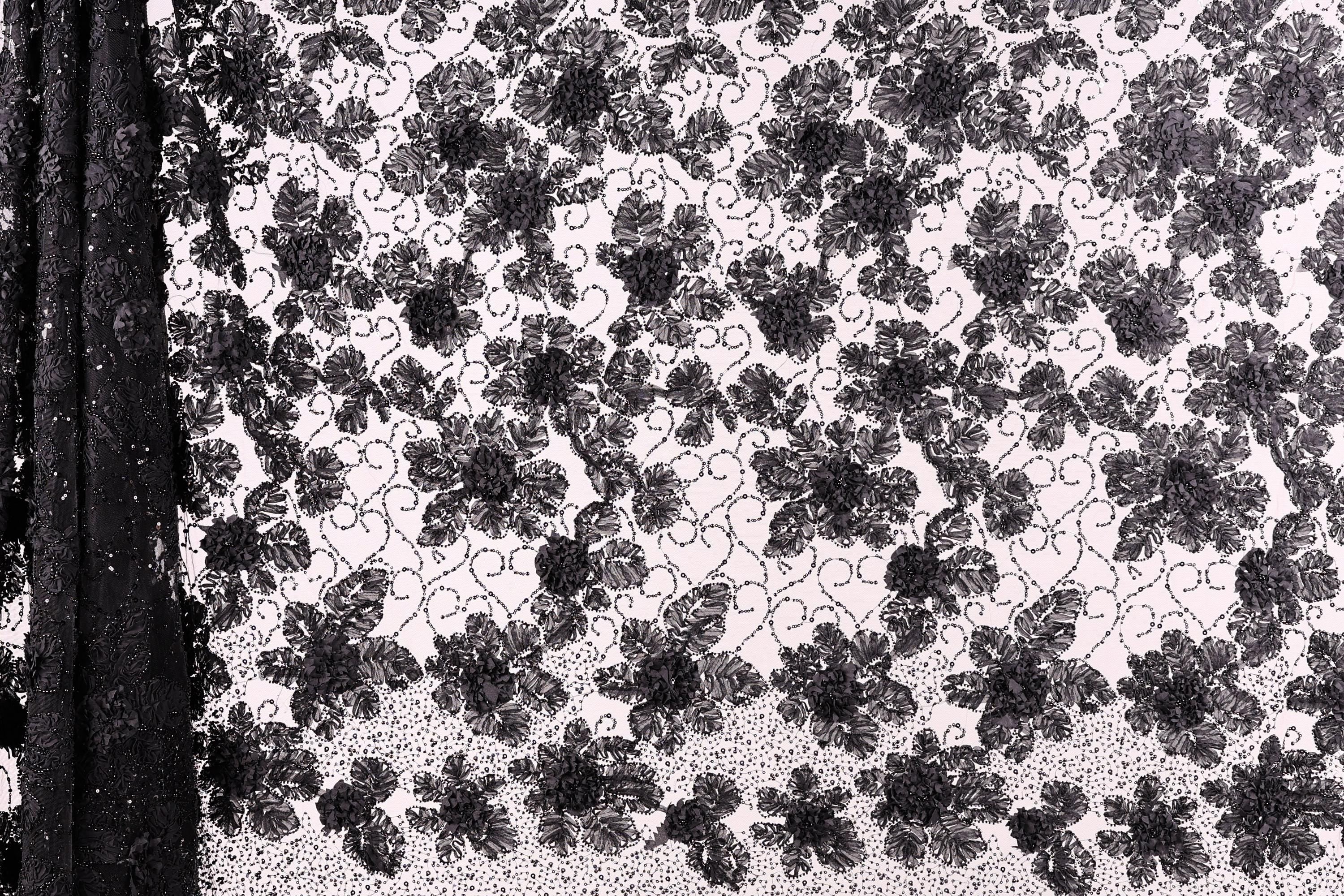 a close-up view of a black and white lace pattern with a repeating floral design.