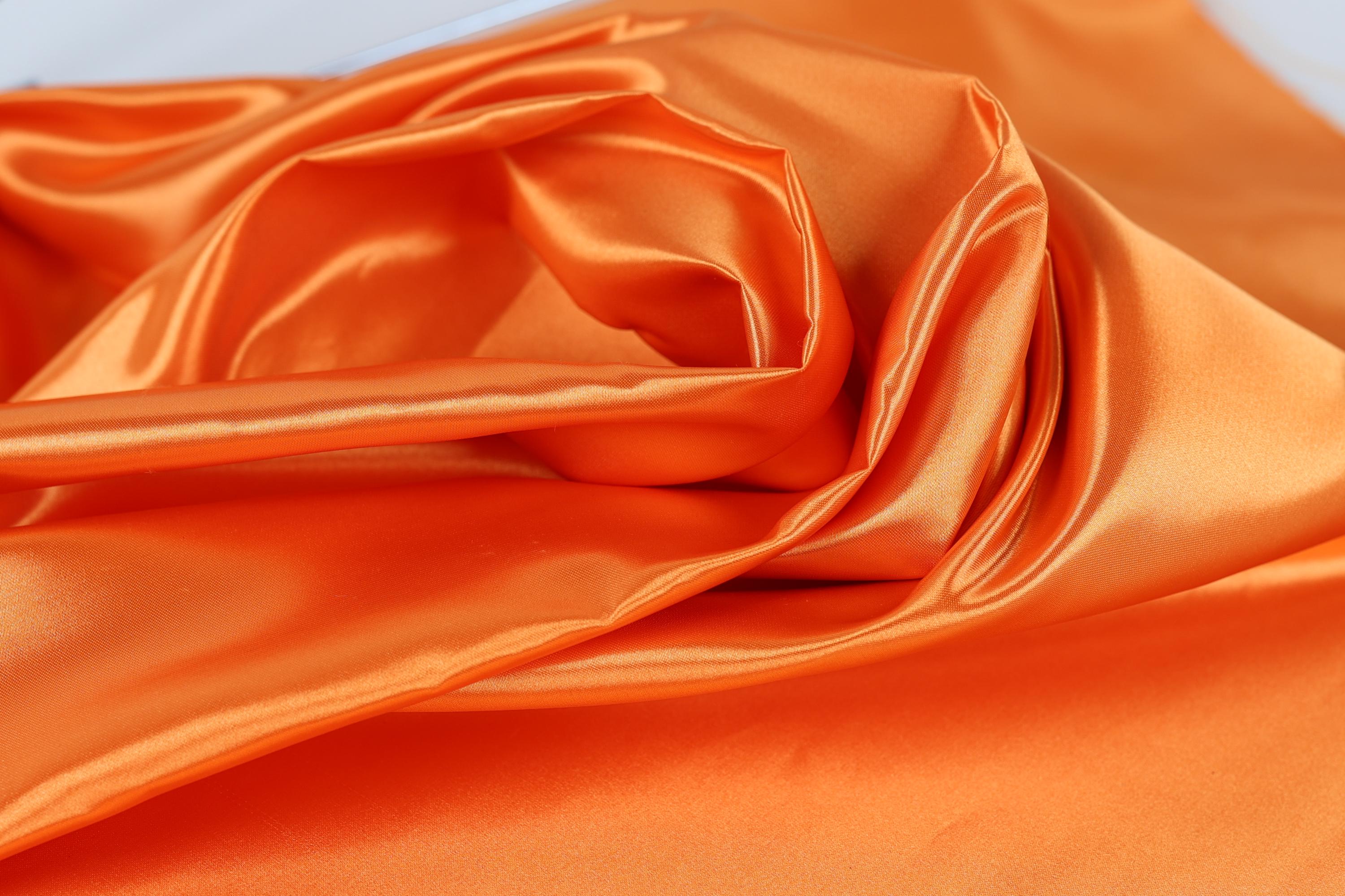 a close-up view of a crumpled orange fabric, with a textured and wrinkled appearance.