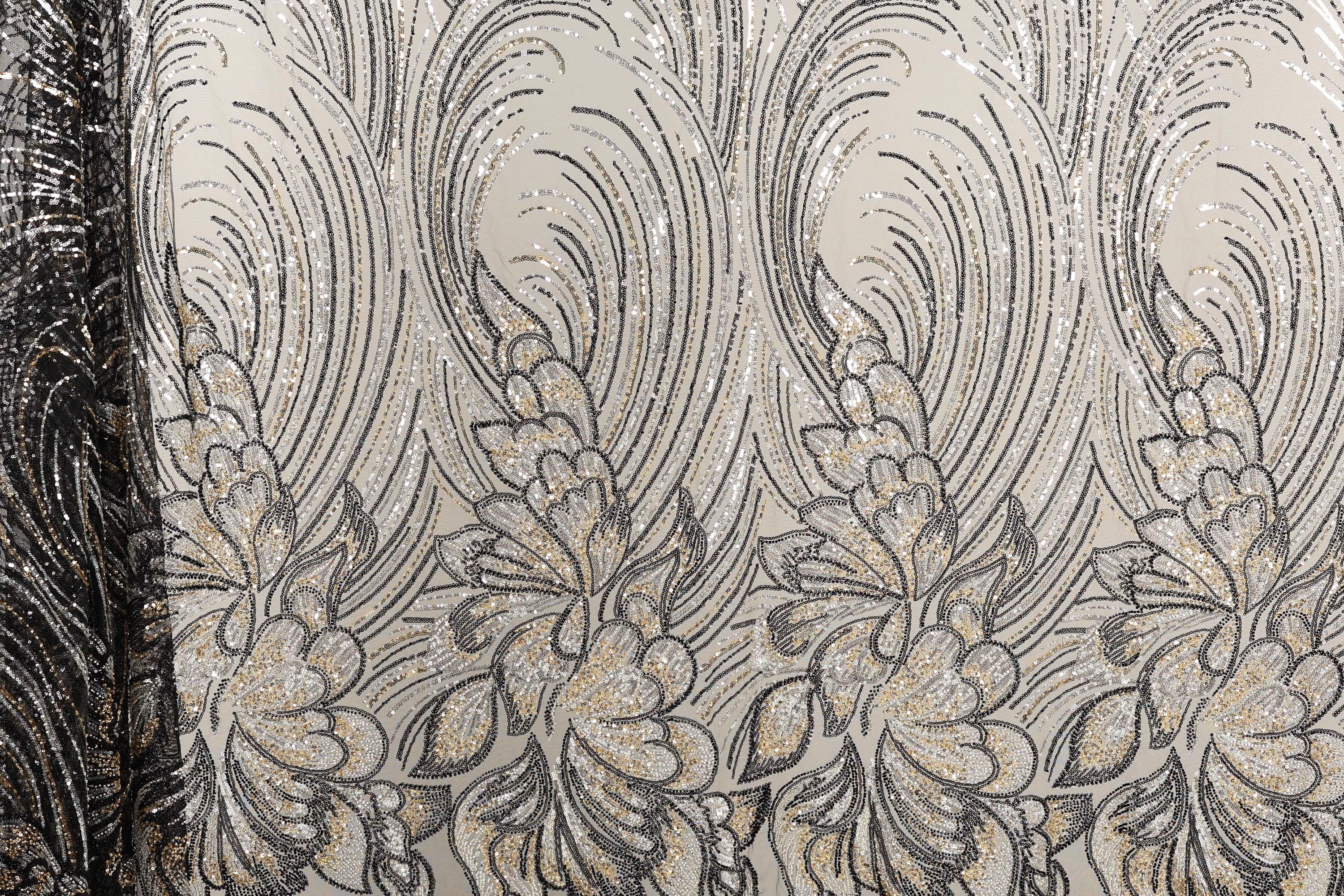 a close-up view of a fabric with a repeating floral pattern in shades of black and gold. The pattern consists of stylized flowers and leaves, creating a visually striking and intricate design. The fabric appears to be made of a shiny, metallic material, which adds a unique texture and visual interest to the overall composition.
