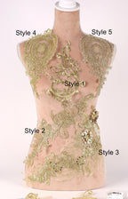 A mannequin with gold embroidered details on its chest and back, showcasing various styles of lace or embroidery.