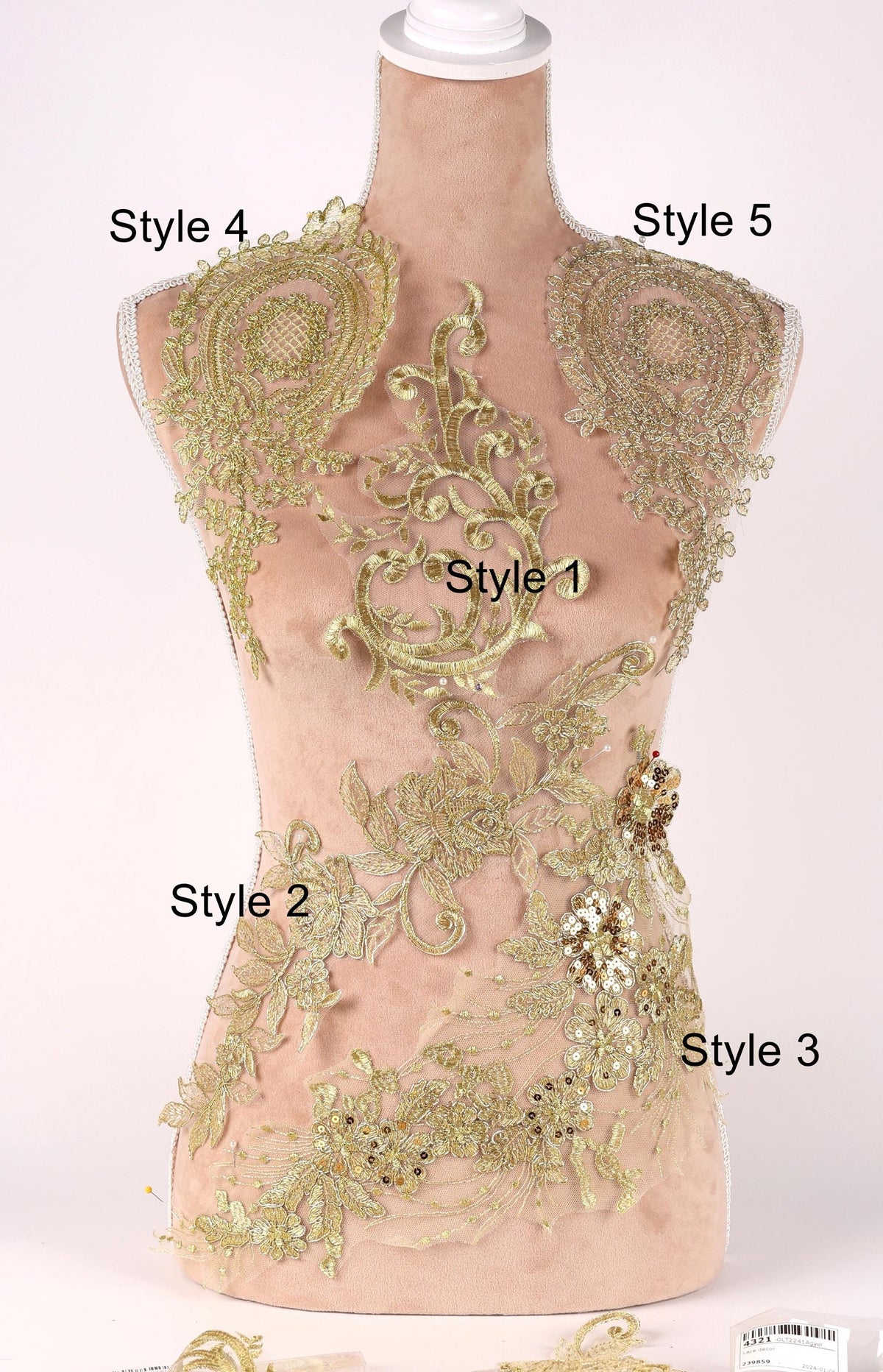 A mannequin with gold embroidered details on its chest and back, showcasing various styles of lace or embroidery.