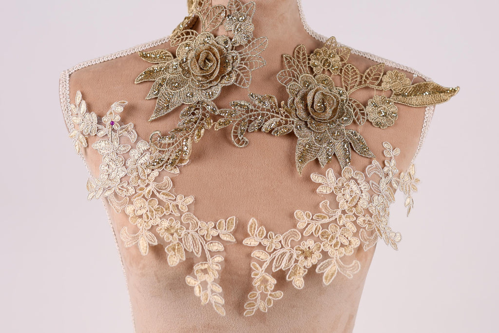 A mannequin wearing a gold and white floral dress with intricate embroidered details.