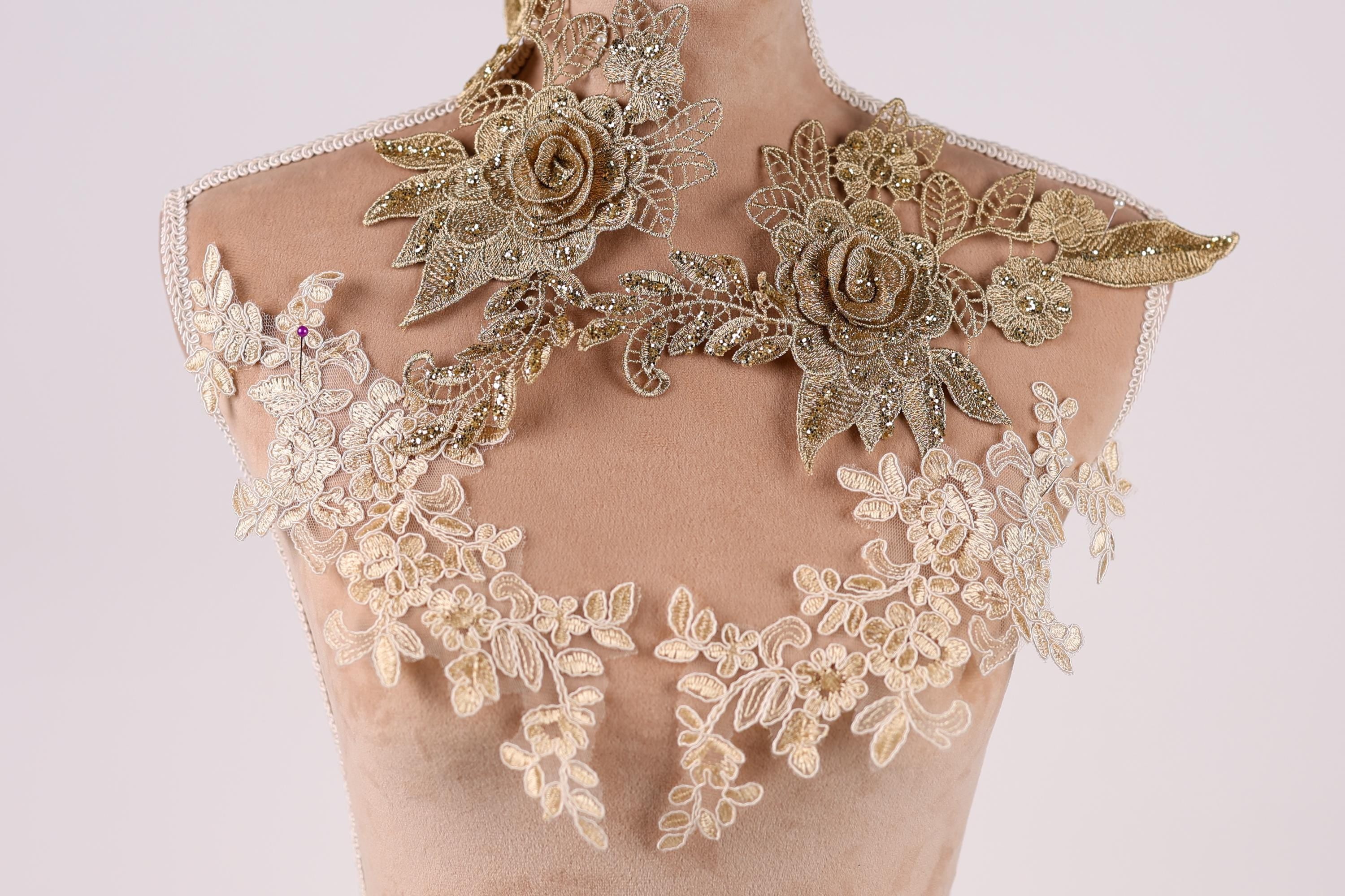 A mannequin wearing a gold and white floral dress with intricate embroidered details.