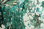 a close-up view of a fabric with a green and blue floral pattern, with a blurred background.