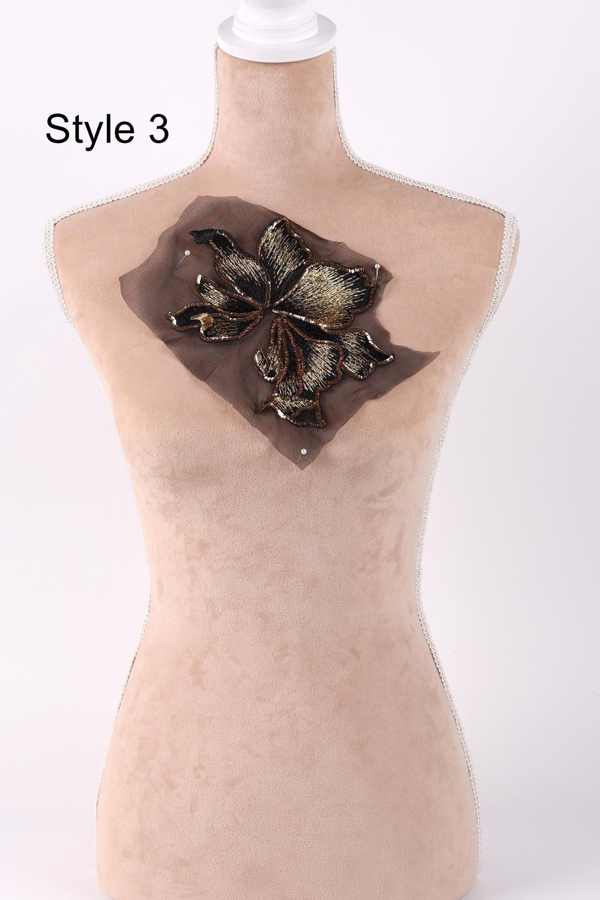 A mannequin with a decorative flower embroidered on its chest.