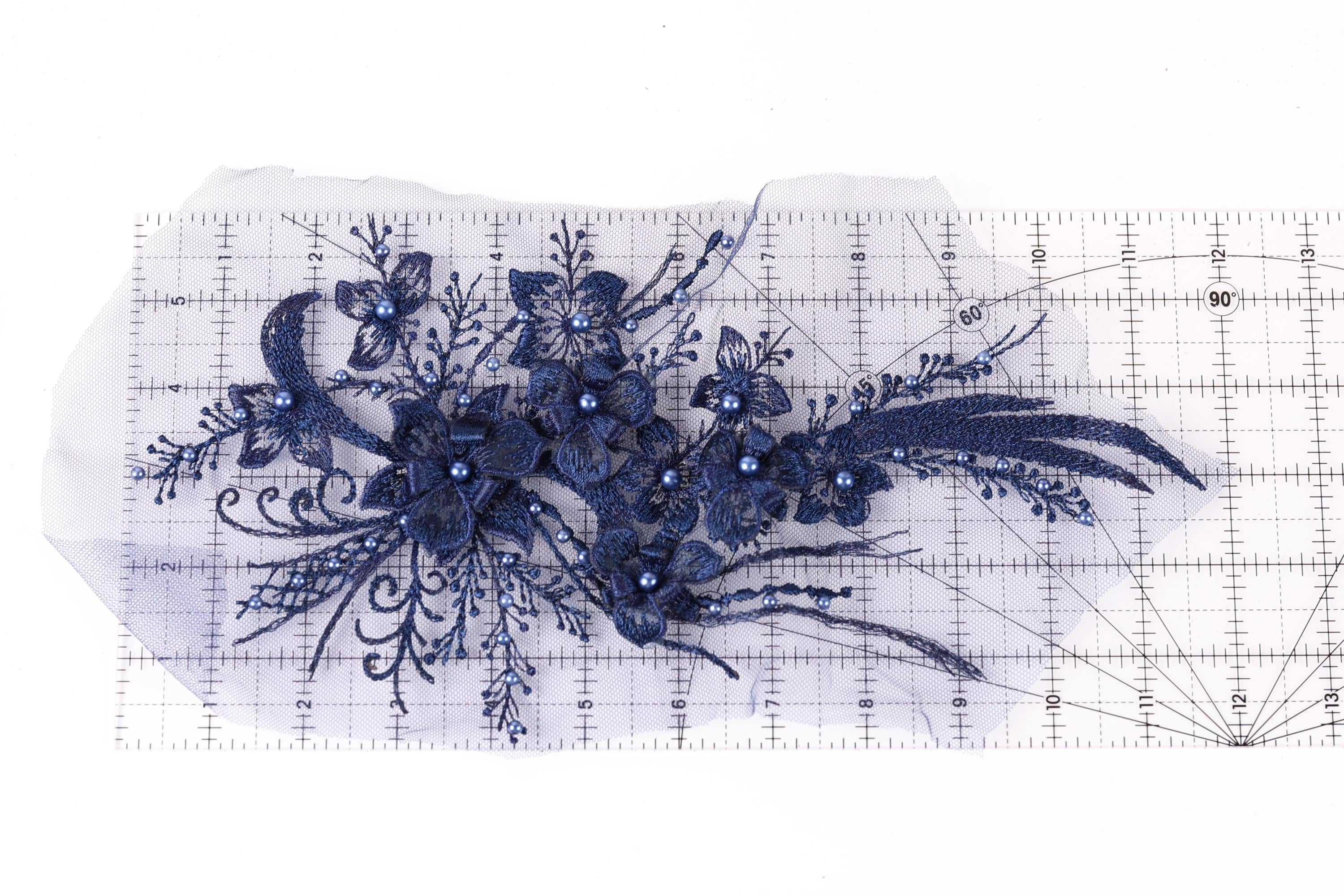 a close-up view of a delicate blue floral embroidery piece, with intricate details and a vibrant blue color.