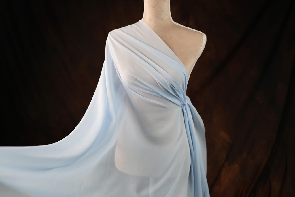 a mannequin dressed in a blue dress with a flowing fabric