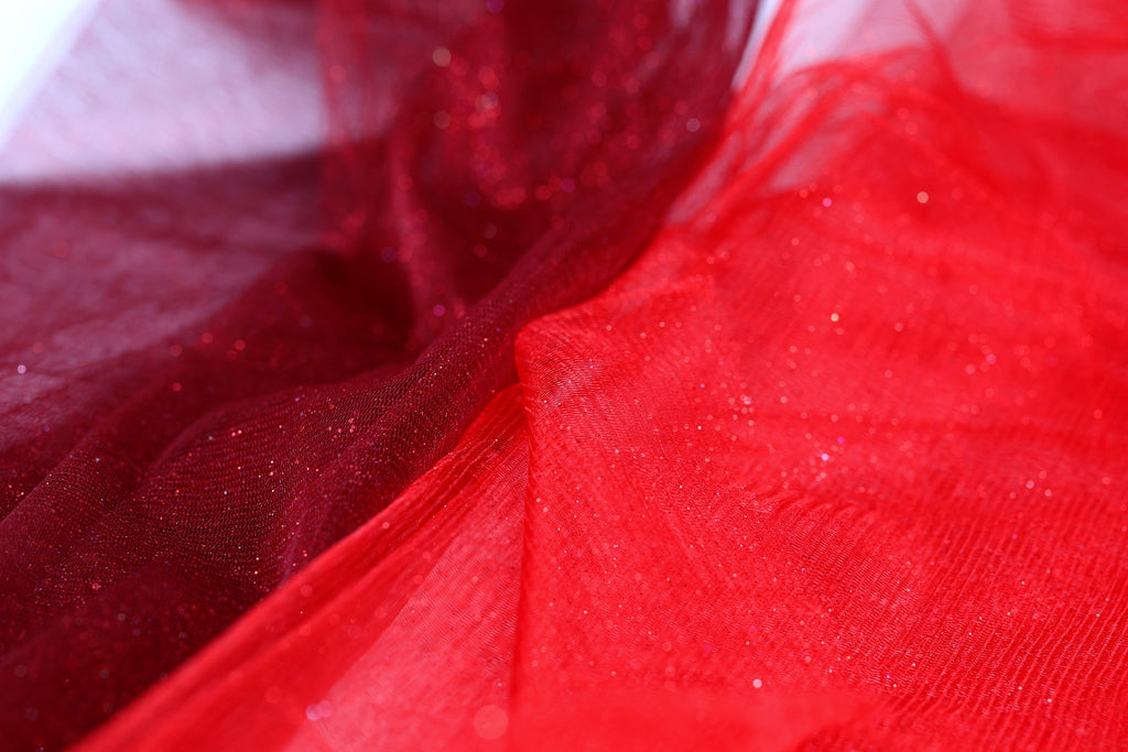 The image is a close-up of a red and red fabric, with the red fabric appearing more vibrant and detailed than the red fabric.