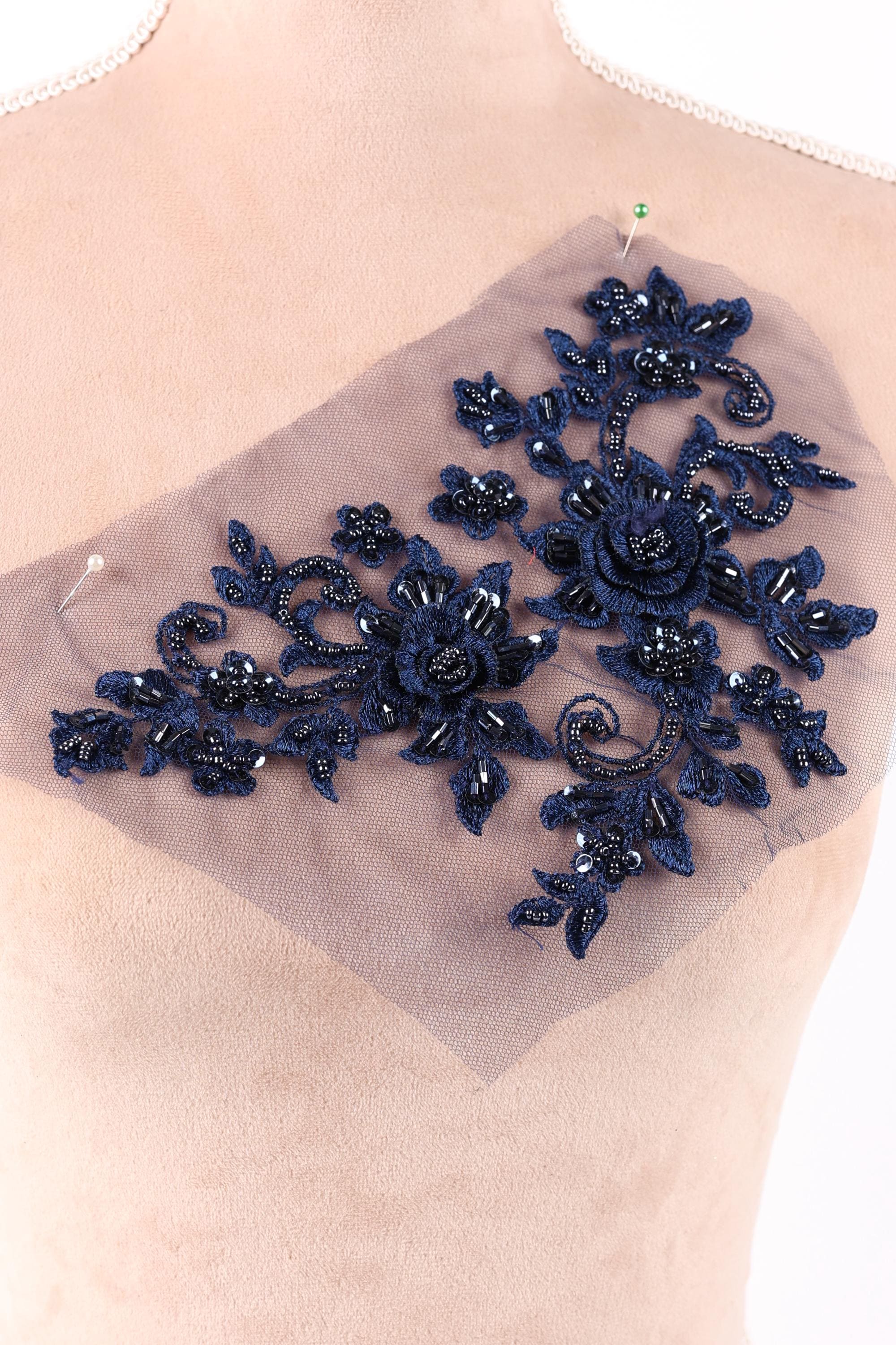 a close-up view of a piece of fabric with a floral pattern, featuring blue flowers and leaves.