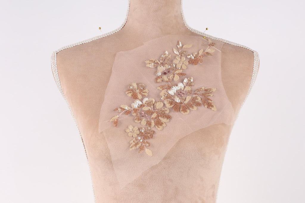 A mannequin with a delicate floral embroidered on its back.