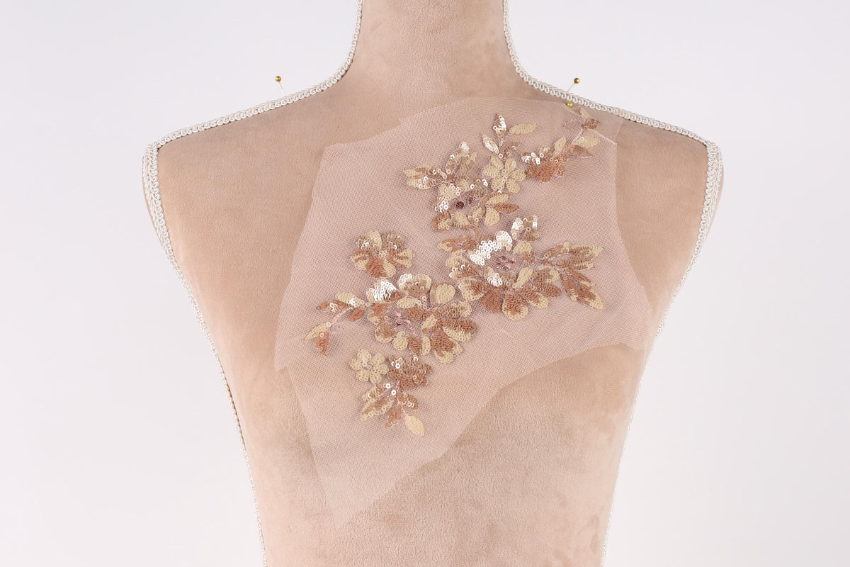 A mannequin with a delicate floral embroidered on its back.