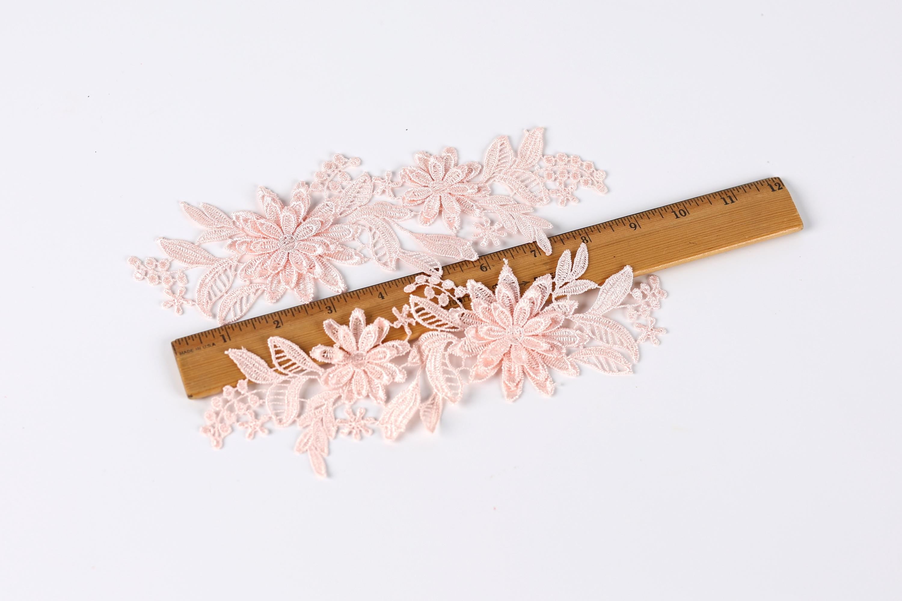 delicate pink lace flowers arranged on a wooden ruler, showcasing the intricate details of the floral patterns.