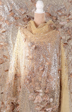 a mannequin wearing a gold and beige sequined dress with a floral pattern.