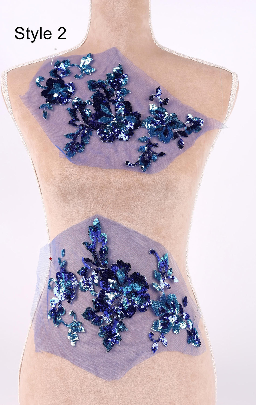 a mannequin with a light-colored fabric on its torso, adorned with a pattern of blue and purple sequins. The sequins are arranged in a decorative manner, creating a visually appealing design.