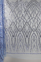 a close-up view of a fabric with a repeating pattern of silver sequins and lines, creating an intricate and visually striking design.