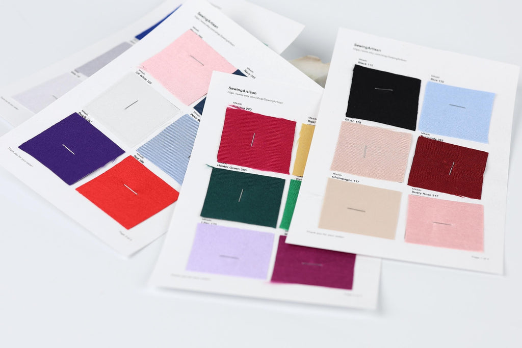several fabric swatches or color samples, each with a different color and pattern, arranged on a white background.