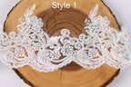 a close-up view of a delicate white lace fabric with intricate floral designs, placed on a wooden surface.