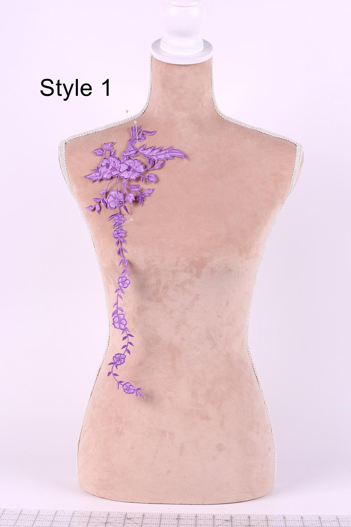 A mannequin with a floral embroidered design on its shoulder.