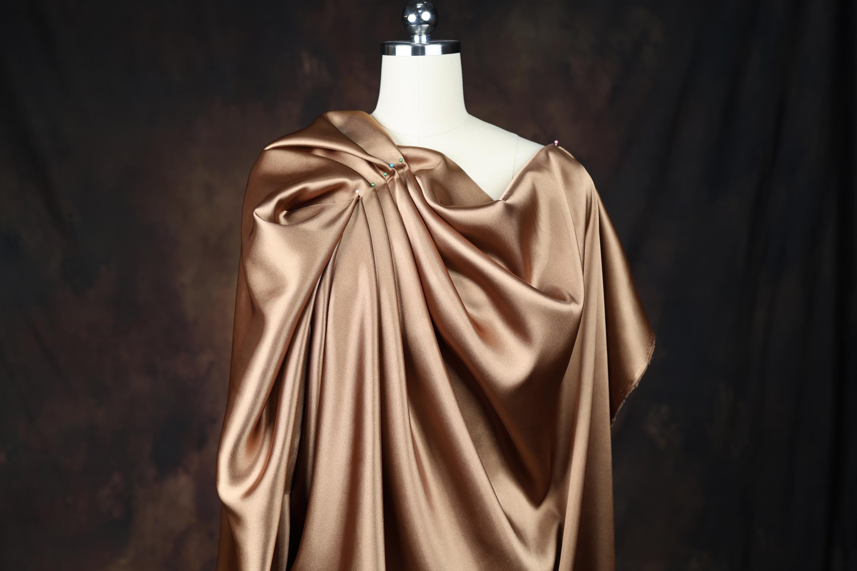a mannequin wearing a brown satin dress