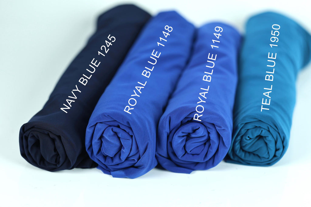 four rolled-up blue shirts, each with a different color label indicating the color and year.